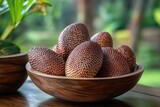 Wooden bowl on the table containing salak or snake fruit