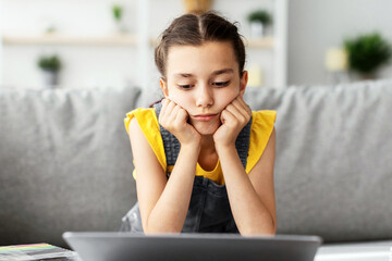 Poster - Boredom Concept. Sad Young Girl Sitting At Desk Using Laptop At Home, Looking At Computer Screen. Tired Upset Adolescent Having Problems, Watching Webinar, Distance Learning Concept