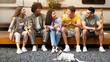 © Prostock-studio - Positive diverse friends and their pet dog sitting near motorhome, having fun together outdoors. Group of multiracial millennials relaxing on camping trip, speaking to each other in countryside