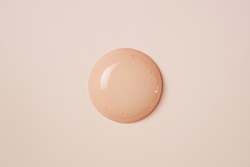 Poster - Liquid foundation makeup sample forming a flawless circle on a smooth, peach-colored surface, highlighting its rich texture and elegant color, perfect for enhancing natural beauty