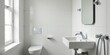 © vattana - Modern minimalist bathroom interior design showcasing sleek white tiling, a compact toilet, and a contemporary sink with chrome fixtures.