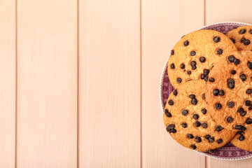 Wall Mural - Plate of tasty cookies with chocolate chips on wooden background, closeup