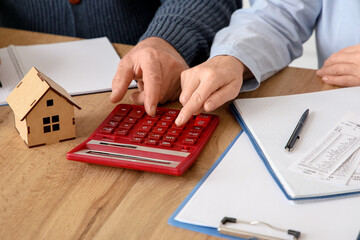 Wall Mural - Senior couple calculating utility bills at table in kitchen, closeup