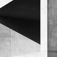 A striking monochrome abstract view of a concrete architectural structure, highlighting sharp angles, light, and shadow interaction, creating visual intrigue.