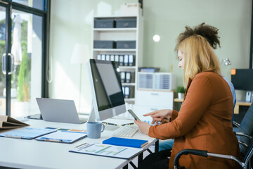 Wall Mural - An African American businesswoman and a Caucasian woman work at analyzing market data, developing business strategies,discussing financial growth while using a laptop spreading money for investment