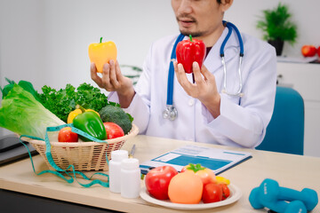 Wall Mural - A male nutritionist sitting at a table, advising on healthy diets, promoting vegetable-based meals, supplements, weight loss, and meal planning to improve overall health and well-being