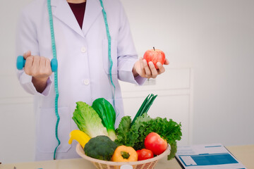 Wall Mural - A male nutritionist sitting at a table, advising on healthy diets, promoting vegetable-based meals, supplements, weight loss, and meal planning to improve overall health and well-being