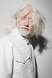 © SHOTPRIME STUDIO - Portrait of a senior man with long white hair and beard, wearing a white jacket, expressing calmness and serenity against a minimalistic light background