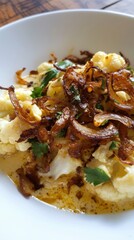 Wall Mural - Spicy cauliflower curry with crispy onions in a white bowl