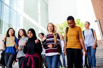 Fototapete - Diverse group of young adults walking down stairs. Students, diverse, young adults, walking. Group of students, diverse backgrounds, walking together. Diverse students hanging out after school.