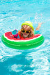 © Volodymyr - Happy kid playing with colorful swim ring in swimming pool on summer day. Child water vacation. Children play in tropical resort.