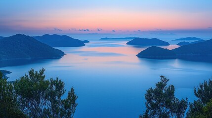 Wall Mural - Islands dot calm sea, soft sky at twilight.