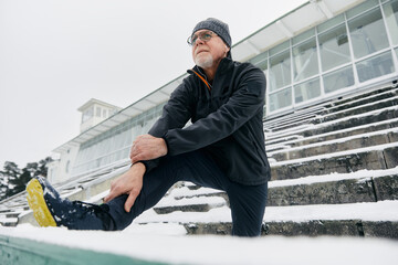 Elderly Man Stretching Leg Before Outdoor Exercise