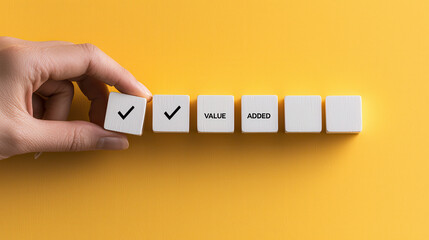 Poster - hand placing white blocks with check mark and text value added on yellow background, symbolizing qua
