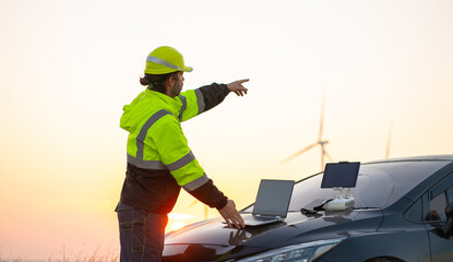 Wall Mural - engineer with laptop survey work in wind turbine farms rotation to generate electricity energy. main