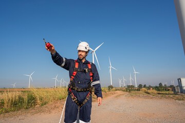 Wall Mural - engineer wearing uniform inspection and survey work in wind turbine farms rotation to generate elect