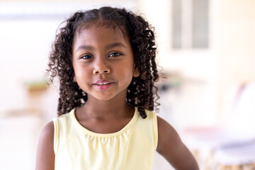 African American girl outdoors close-up child pretty smiling looking at camera ethnic schoolgirl standing in park portrait cute small baby pupil kid daughter face in city headshot custody.