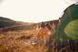 © Zoran Zeremski - Two women camping at top of the hill sitting in front of the tent.