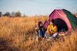 © Zoran Zeremski - Two women camping at top of the hill sitting in front of the tent.