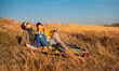 © Zoran Zeremski - Two woman sitting at top of the hill at meadow resting after hiking.