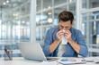 © Liubomir - Sick man suffering at workplace, sneezing. Worker has runny nose and cold blowing snot into a napkin. Working with laptop inside office.