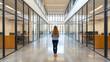 © Teeranan - A businesswoman stands in the middle of an office, looking at glass walls on one side and high ceilings on the other. She is wearing professional attire with her long hair flowing behind her