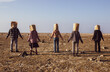 © ОК - People are standing on the ground with bags over their heads.