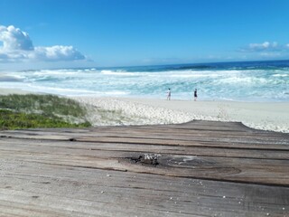 Poster - Serene beach scene with wooden walkway and ocean.