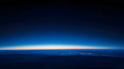 Wall Mural - a dark blue sky at dawn, with the first light of day peeking over the horizon