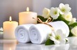 © alexandra nova - Close-up of spa items: white towels with white flowers. It is ideal for creating a brand of wellness services, advertising spa salons or relaxation concepts. The atmosphere is soothing and inviting