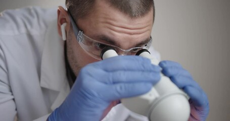 Wall Mural - dedicated scientist is intently examining various samples with high powered microscope inside labora