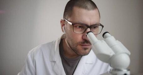 Wall Mural - dedicated scientist is intently examining various samples with high powered microscope inside labora