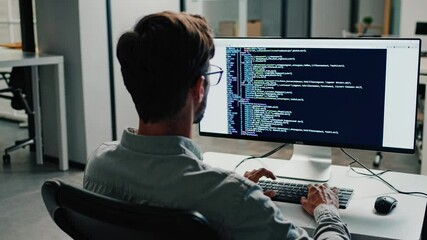 Leinwandbilder - Coding session in a modern office with a programmer working on a desktop computer