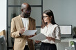 © TrueFrame Collective - Confident young male broker or economist with financial papers discussing data with female colleague
