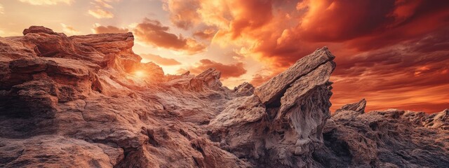Poster - Surreal landscape featuring dramatic rock formations against a reddish orange sunset sky with empty space for text and creative design elements