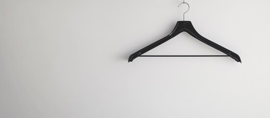 Poster - Black plastic clothes hanger on white wall with ample blank space for advertising or promotional text placement in minimalist setting