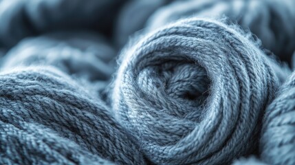 Poster - Close-up of rolled high-quality blue wool yarn for winter fashion showcasing the texture and softness of knitted materials.