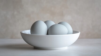 Poster - Minimalist Grey Eggs in Modern White Bowl on Calm Surface for Elegant Kitchen Decor and Culinary Presentation