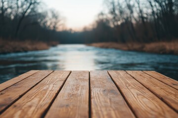 Poster - Peaceful outdoor scene with a wooden table overlooking a flowing river. Soft morning light creates a tranquil atmosphere in earthy tones