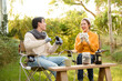 © tonefotografia - Enjoying Warm Drinks and Conversation in a Sunny Outdoor Garden During Autumn Afternoon