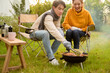 © tonefotografia - Couple Enjoys Grilling Outdoors in a Cozy Garden Setting During a Sunny Afternoon