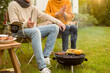 © tonefotografia - Couple Enjoys Grilling Outdoors in a Cozy Garden Setting During a Sunny Afternoon
