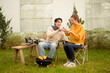 © tonefotografia - Couple Enjoys Grilling Outdoors in a Cozy Garden Setting During a Sunny Afternoon