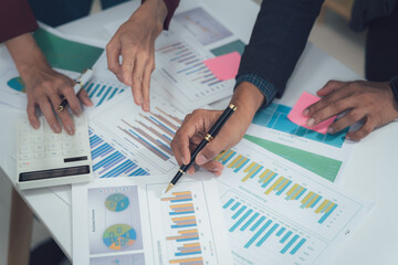 Wall Mural - Strategic Business Analysis: Close-up shot of hands reviewing financial data, charts, and graphs, illustrating collaborative teamwork and detailed financial analysis.