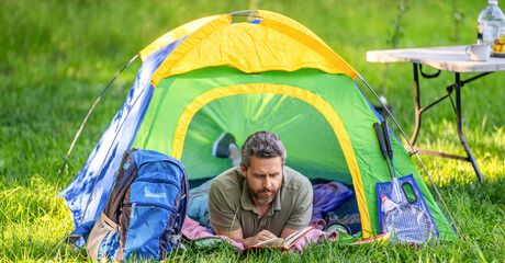 hiking lifestyle. man relax and read book at campsite. inspiration time. man having camp picnic in t