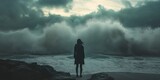 A woman stands against crashing waves, highlighting nature's power and awe.