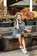 A young girl sits on the street and talks on the phone