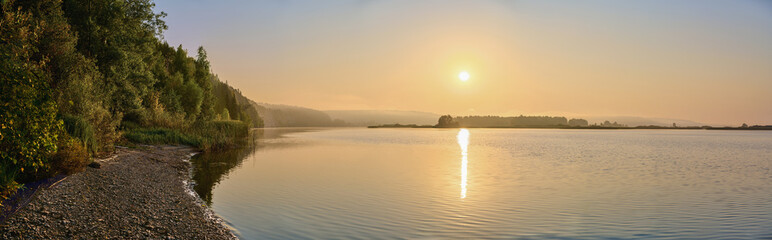 Wall Mural - a panoramic view of the morning fog over the river, with the sun shining through.