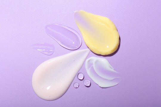 Wall Mural -  - cream and gel samples on violet background, top view