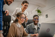 © Miljan Živković - multicultural colleagues work together on laptop in the office